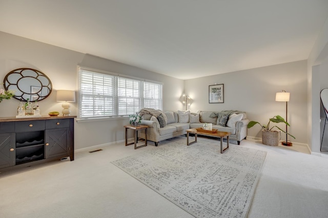 living room featuring baseboards, visible vents, and light colored carpet