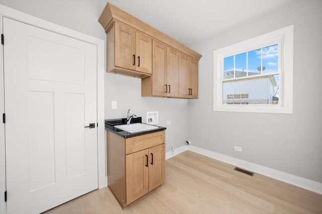 laundry room featuring visible vents, washer hookup, a sink, light wood-style floors, and baseboards