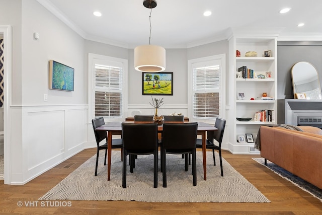 dining area featuring recessed lighting, wainscoting, crown molding, and wood finished floors