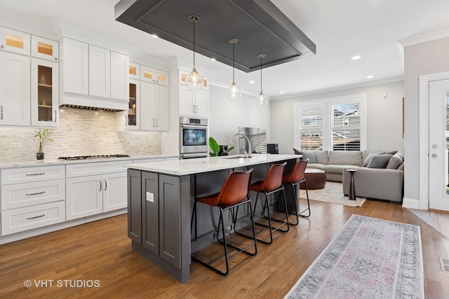 kitchen featuring white cabinets, a kitchen bar, and stainless steel oven