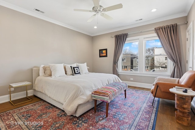 bedroom featuring ornamental molding, visible vents, baseboards, and wood finished floors