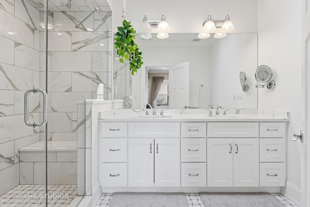 full bathroom with double vanity, a sink, and a stall shower