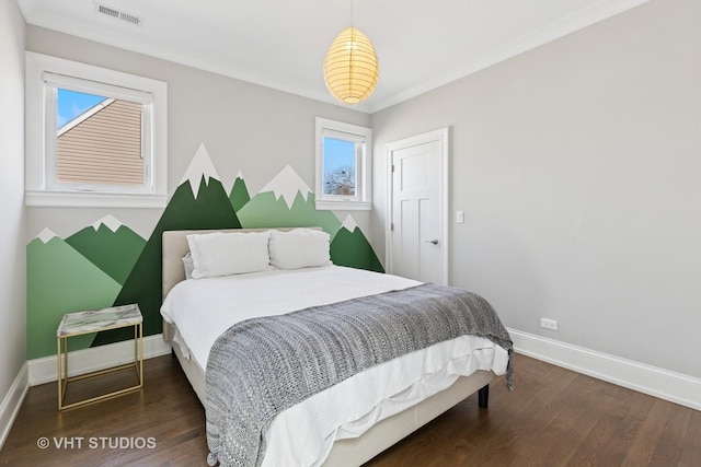 bedroom with visible vents, baseboards, multiple windows, and wood finished floors