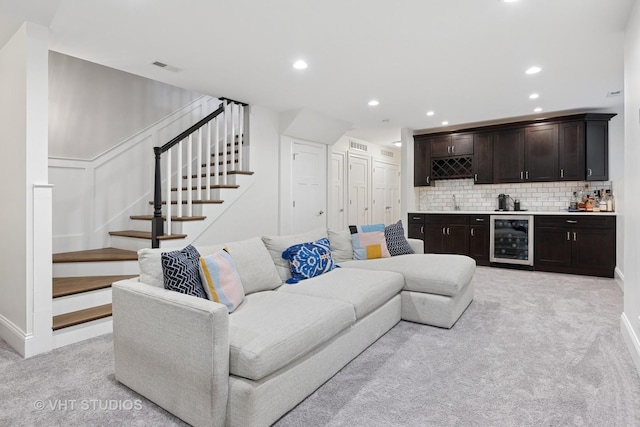 living room with indoor wet bar, stairs, visible vents, wine cooler, and light colored carpet