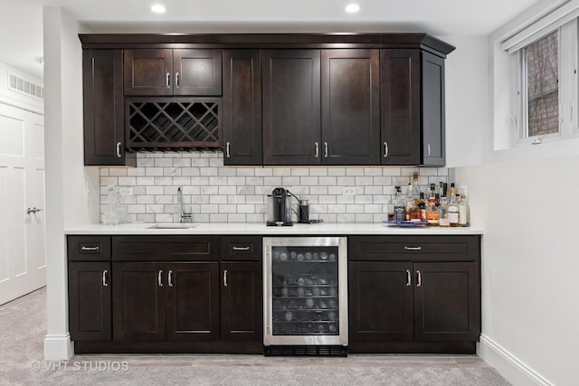 bar with visible vents, indoor wet bar, a sink, wine cooler, and decorative backsplash