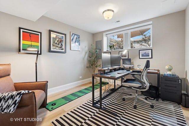 office space featuring wood finished floors, baseboards, and visible vents