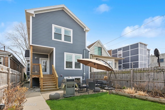 rear view of house featuring a patio, a yard, and fence