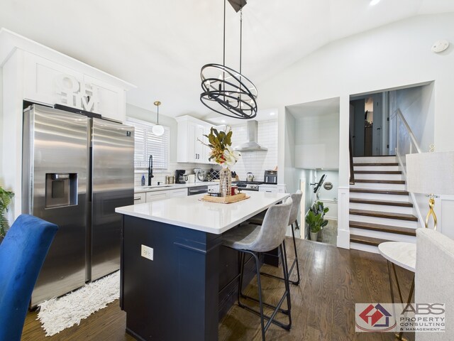 439 Hoxie Ave, Calumet City, IL 60409 - kitchen featuring vaulted ceiling, appliances with stainless steel finishes, wall chimney range hood, and a sink