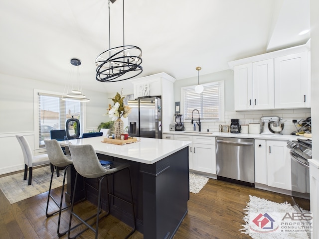 439 Hoxie Ave, Calumet City, IL 60409 - kitchen with a sink, a kitchen island, dark wood finished floors, stainless steel appliances, and light countertops