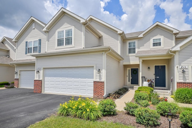 213 Dorset Ave, Oswego, IL 60543 - view of property featuring an attached garage, brick siding, and asphalt driveway