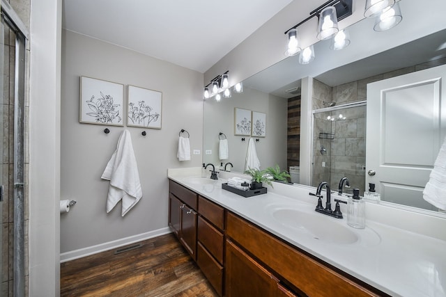 213 Dorset Ave, Oswego, IL 60543 - full bathroom with double vanity, a shower stall, and wood finished floors