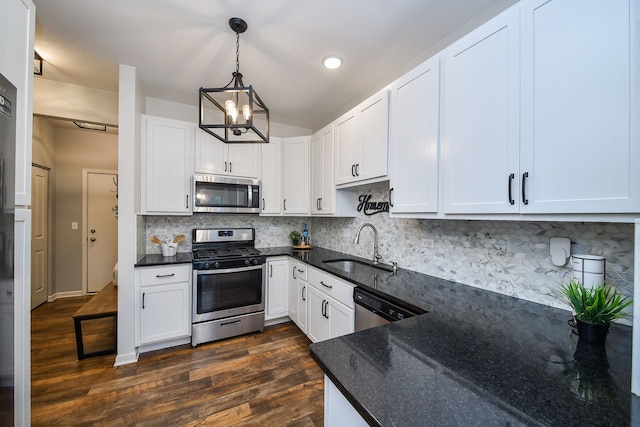 213 Dorset Ave, Oswego, IL 60543 - kitchen featuring appliances with stainless steel finishes, dark wood-type flooring, decorative backsplash, a chandelier, and white cabinets