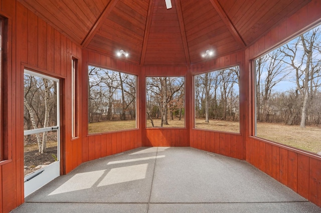 unfurnished sunroom with carpet flooring, wooden ceiling, wood walls, and lofted ceiling