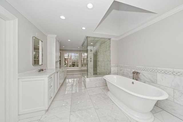 bathroom with marble finish floor, ornamental molding, a freestanding tub, vanity, and a stall shower