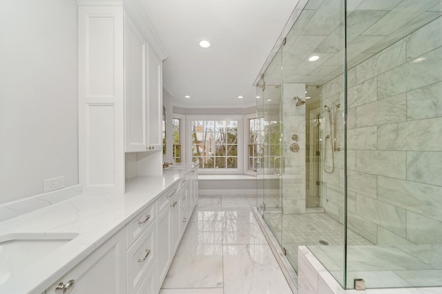 bathroom featuring recessed lighting, ornamental molding, marble finish floor, a stall shower, and double vanity