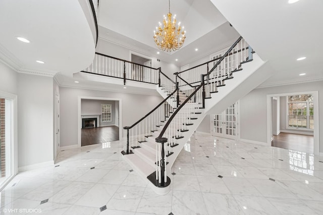 staircase with marble finish floor, ornamental molding, and baseboards