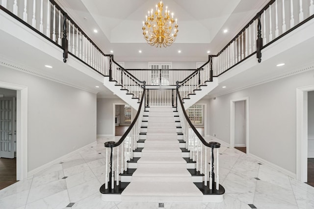staircase with an inviting chandelier, marble finish floor, a towering ceiling, and baseboards