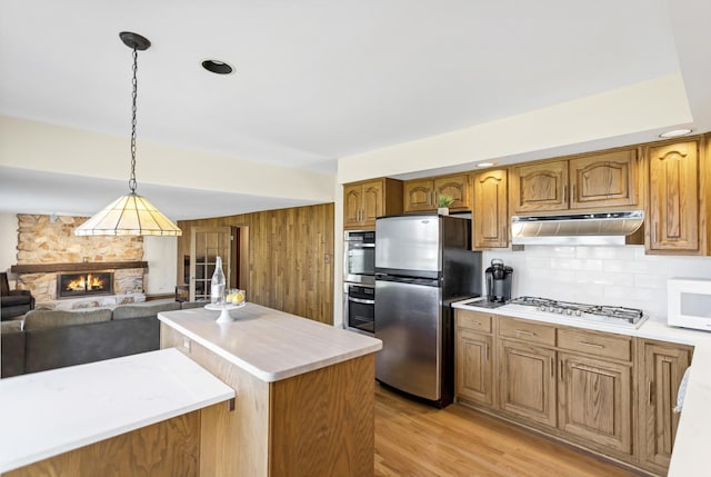 915 N Saratoga Dr, Palatine, IL 60074 - kitchen featuring under cabinet range hood, light countertops, freestanding refrigerator, white microwave, and gas stovetop