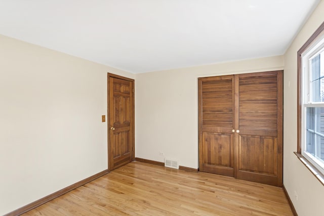 915 N Saratoga Dr, Palatine, IL 60074 - unfurnished bedroom featuring light wood-type flooring, baseboards, visible vents, and a closet