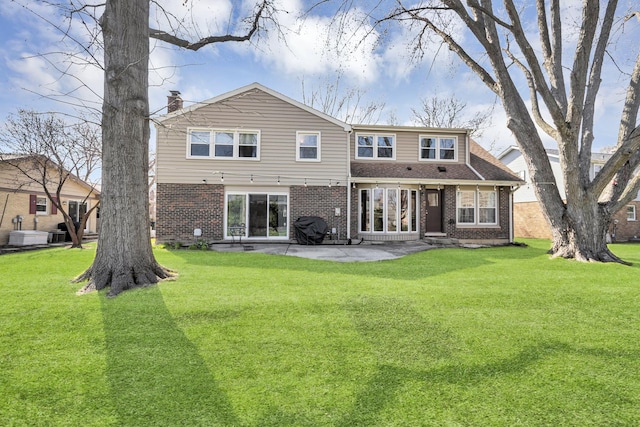 915 N Saratoga Dr, Palatine, IL 60074 - back of house featuring a yard, brick siding, and a patio area