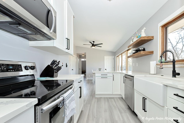 kitchen with white cabinetry, a sink, appliances with stainless steel finishes, and a wealth of natural light