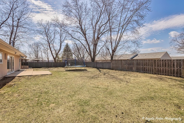 view of yard featuring a fenced backyard, a patio, and a trampoline