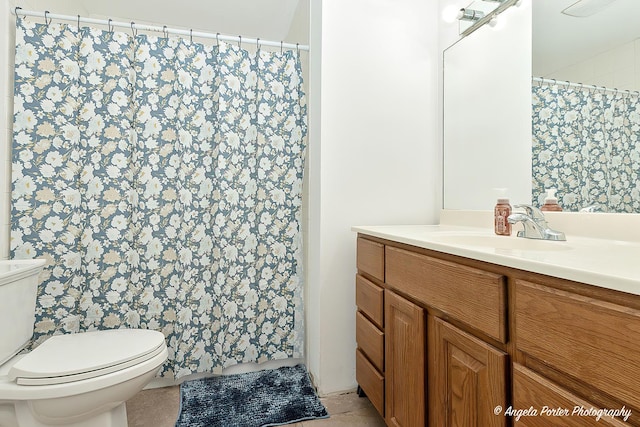 bathroom featuring a shower with curtain, toilet, and vanity