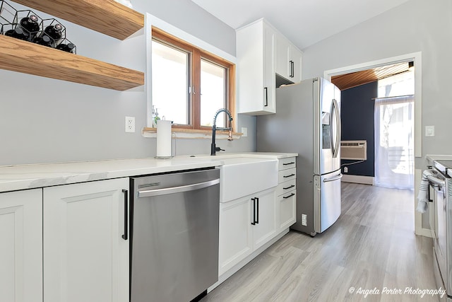 kitchen featuring light countertops, a sink, white cabinetry, appliances with stainless steel finishes, and light wood-type flooring