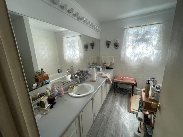 221 Heine Ave, Elgin, IL 60123 - bathroom featuring vanity, wood finished floors, a garden tub, and tile walls