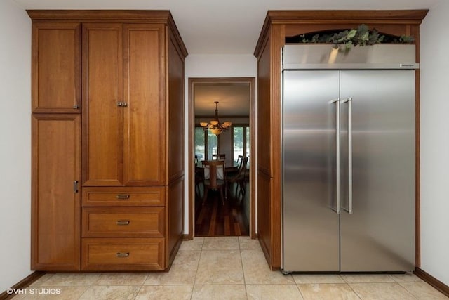 307 Anne Ct, Prospect Heights, IL 60070 - kitchen featuring built in refrigerator, brown cabinetry, a chandelier, and light tile patterned flooring