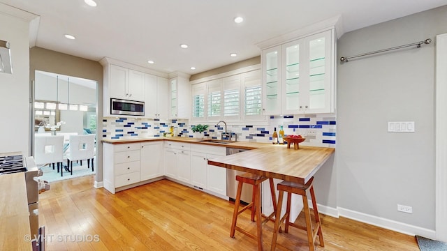 kitchen featuring a sink, appliances with stainless steel finishes, white cabinets, and a wealth of natural light