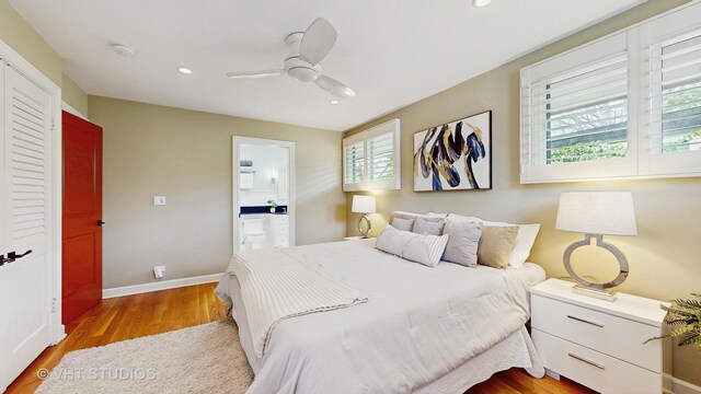 bedroom with baseboards, ensuite bath, recessed lighting, and light wood-style flooring