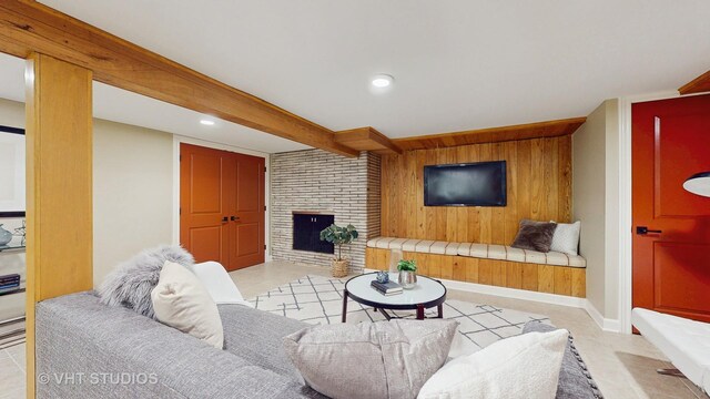 living room with wooden walls, baseboards, a brick fireplace, and recessed lighting