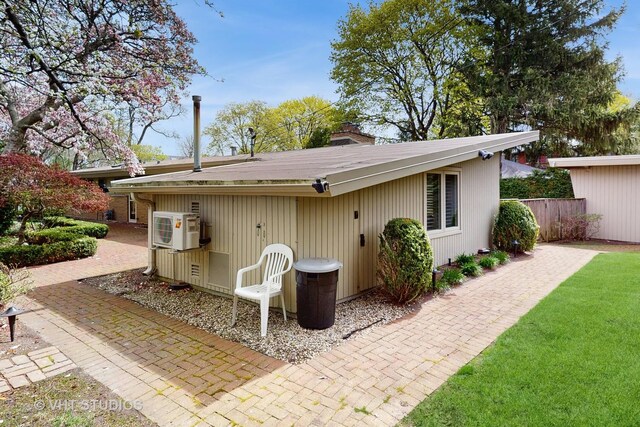 back of property with fence, ac unit, and a chimney