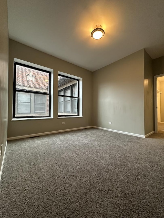 unfurnished room with baseboards and carpet floors