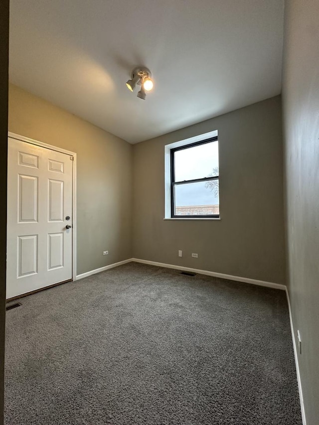 carpeted empty room featuring visible vents and baseboards