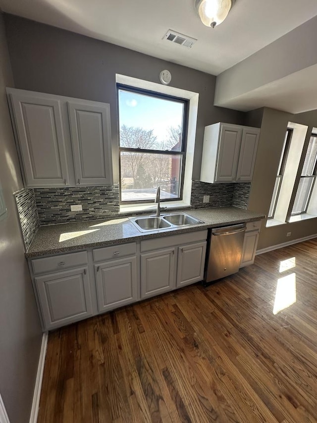 kitchen featuring white cabinets, dishwasher, visible vents, a sink, and dark wood-type flooring