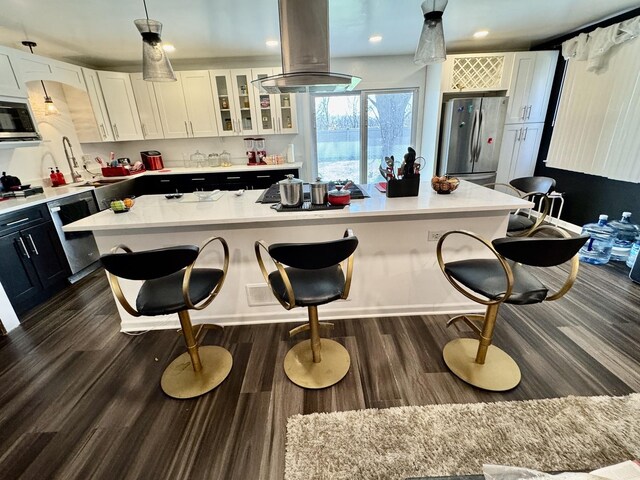 5125 Imperial Dr, Richton Park, IL 60471 - kitchen with white cabinets, appliances with stainless steel finishes, a breakfast bar, and island exhaust hood