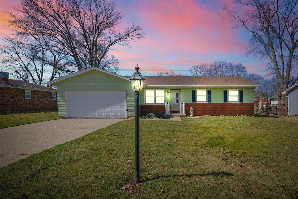 2601 S Anderson St, Urbana, IL 61801 - ranch-style home featuring brick siding, concrete driveway, a front lawn, and an attached garage