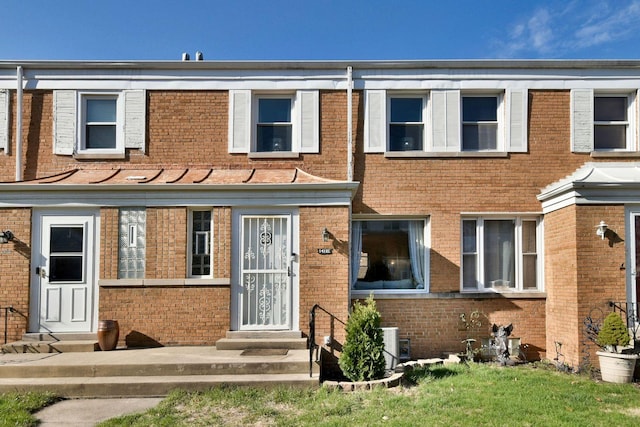 view of property with entry steps and brick siding