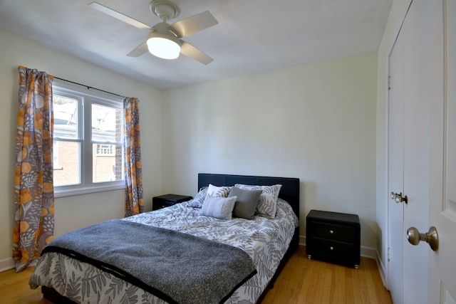 bedroom with baseboards, ceiling fan, and light wood-style floors