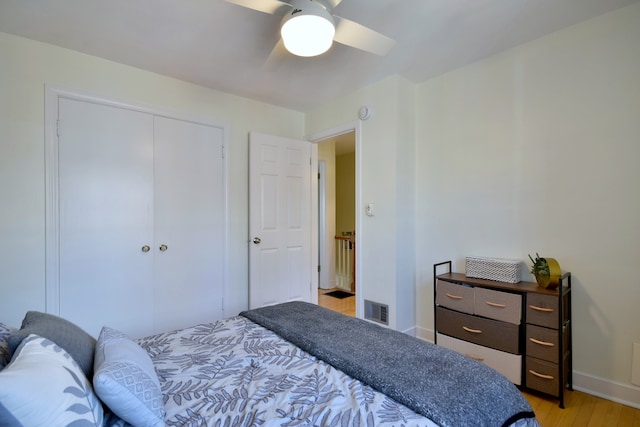 bedroom with visible vents, baseboards, a closet, a ceiling fan, and light wood-style floors