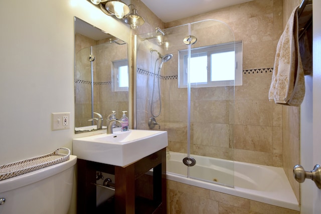 full bath featuring toilet, tiled shower / bath combo, and vanity