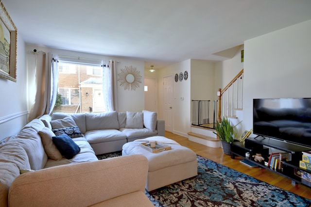 living area featuring light wood-style flooring and stairs