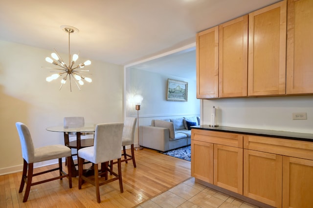 dining area featuring light wood-type flooring and an inviting chandelier