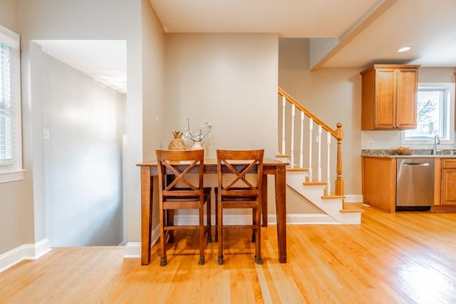 dining room featuring light wood-style floors, baseboards, recessed lighting, and stairs