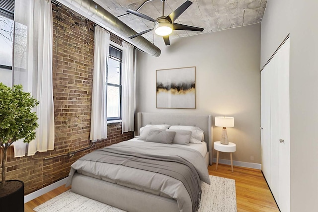 110 N Peoria St Unit 205, Chicago, IL 60607 - bedroom featuring brick wall, light wood-style floors, baseboards, and ceiling fan