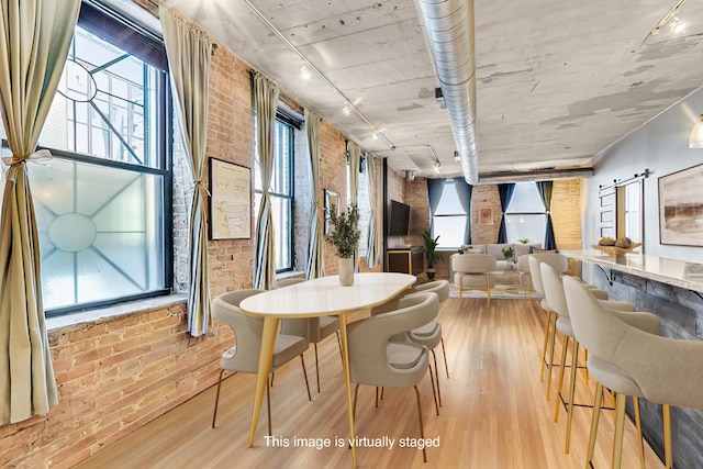 110 N Peoria St Unit 205, Chicago, IL 60607 - dining room featuring brick wall, wood finished floors, and healthy amount of natural light