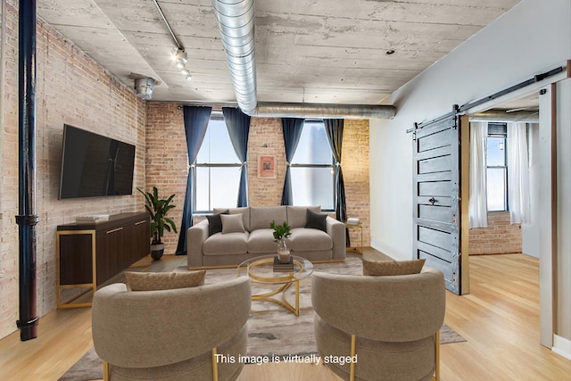 110 N Peoria St Unit 205, Chicago, IL 60607 - living room with brick wall, a barn door, light wood-type flooring, track lighting, and baseboards