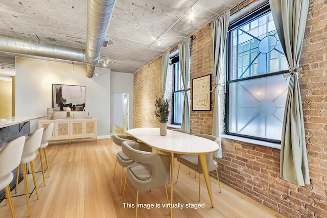 110 N Peoria St Unit 205, Chicago, IL 60607 - dining room with brick wall, wood finished floors, healthy amount of natural light, and baseboards